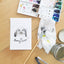 Painting a rabbit pet watercolor portrait illustration with paintbrush and palette.
