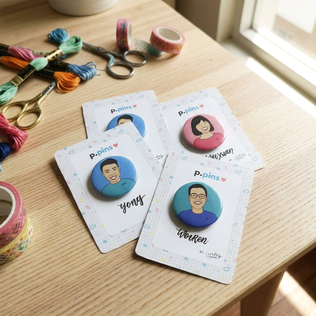 Four buttons on cards with people's faces on a wooden table with crafting supplies.