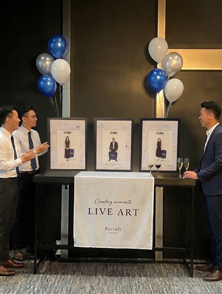 Three men interacting with a 'Live Art' display featuring framed pictures and balloons.