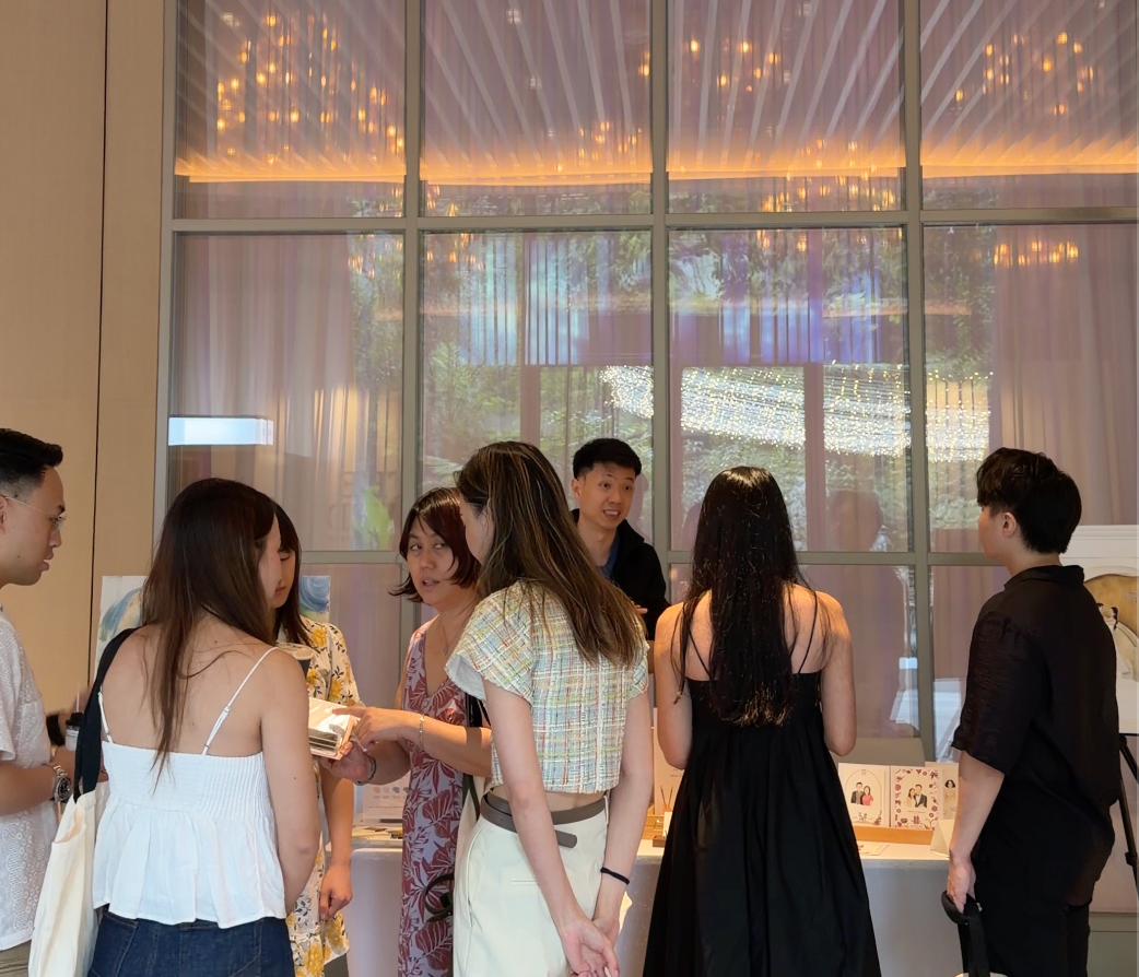 Group of people socializing in a modern indoor setting with large windows.
