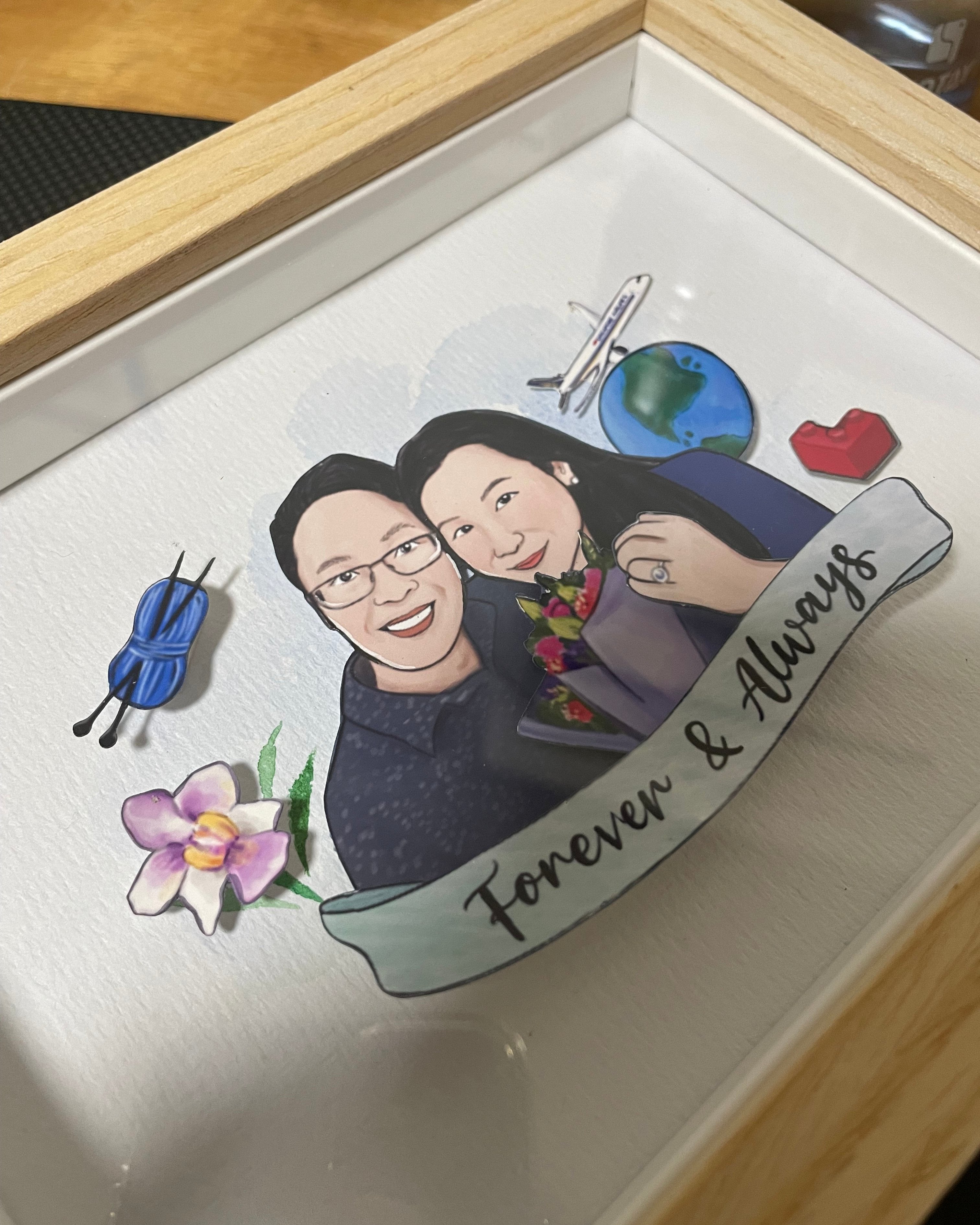 A papercut frame featuring a couple and illustration items that tell their story