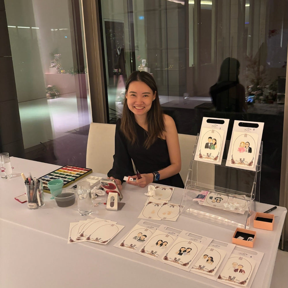 Woman sitting at a table with art supplies and cards in an indoor setting