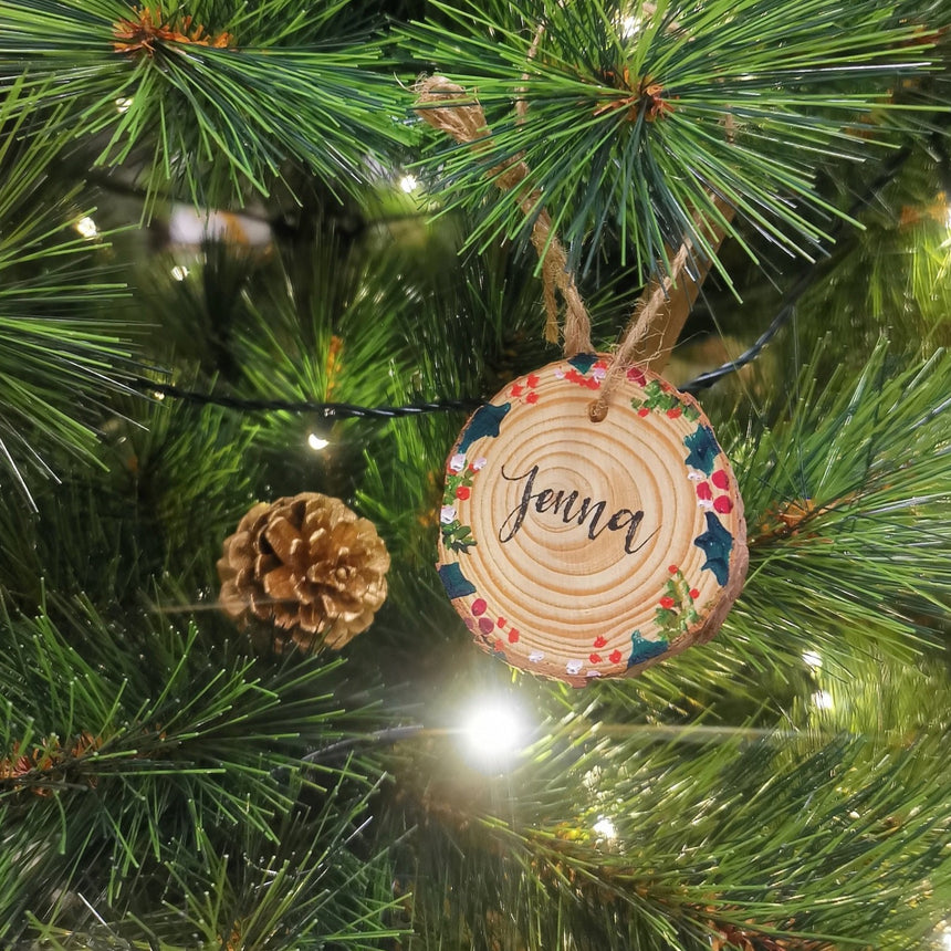 Christmas themed wood tag hanging on a Christmas tree
