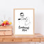 Black and white portrait line art with calligraphy in a brown frame on a wooden table.