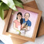 Digitally illustrated couple portrait paired with a pink dried floral bouquet in a wood frame.